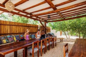 a group of people sitting at a long wooden table at Island Escape for Groups Hosted by Atenea Holbox in Holbox Island