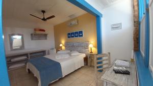 een slaapkamer met een bed en een tafel met een spiegel bij Pousada Flor do Mar in Paraty