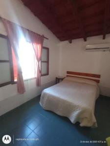 ein Schlafzimmer mit einem weißen Bett und einem Fenster in der Unterkunft Hosteria sol naciente in Cafayate