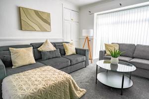 a living room with a couch and a table at Elm House in Bathgate