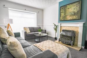 a living room with a couch and a fire place at Elm House in Bathgate