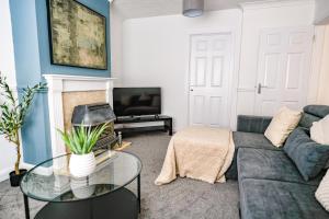 a living room with a couch and a tv at Elm House in Bathgate +35 photos