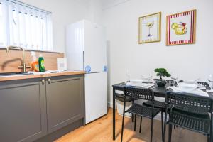 a kitchen with a table and a refrigerator at Elm House in Bathgate