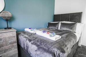 a bedroom with a bed with two towels on it at Elm House in Bathgate