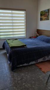 a bedroom with two beds and a large window at CostaMonkul in Nahuentúe
