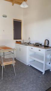 a kitchen with a sink and a table and a chair at CostaMonkul in Nahuentúe