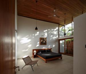 a bedroom with a bed and a chair at Clover Bentota in Dedduwa