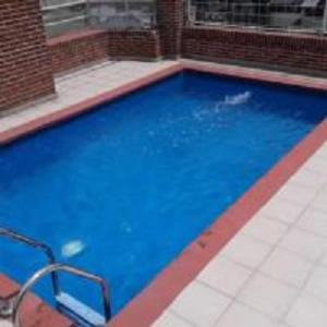 a large blue swimming pool in a building at Todo cerca en la ciudad in Buenos Aires