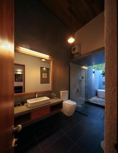 a bathroom with a toilet and a sink and a mirror at Clover Bentota in Dedduwa +29 photos