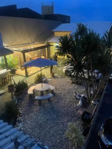 a patio with a table and umbrella and palm trees at Pousada Morada dos Guarás in Ilha Comprida