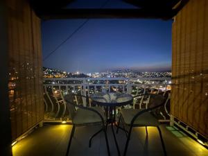a table and chairs on a balcony at night at SarajevoView in Ivišovo Greblje