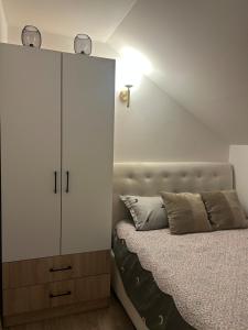 a bedroom with a large white cabinet next to a bed at SarajevoView in Ivišovo Greblje