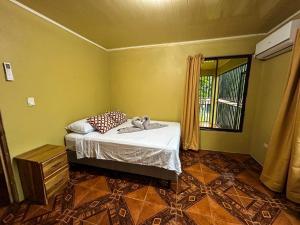 een slaapkamer met een bed met een knuffeldier erop bij Cabaña La Conquista in Sarapiquí