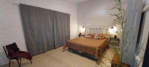 a bedroom with a bed and a chair in it at La Casita de Oreste in Cosquín +8 photos