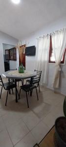 a dining room table with chairs and a vase on it at La Casita de Oreste in Cosquín