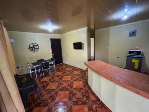 een bar in een kamer met een tafel en stoelen bij Cabaña La Conquista in Sarapiquí
