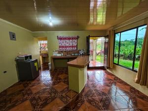 a kitchen with a counter in a room with windows at Cabaña La Conquista Naturaleza aves y tranquilidad en Sarapiquí cerca de la Selva in Sarapiquí