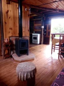 a living room with a stove in a cabin at Cabaña Alcione in Capilla del Monte
