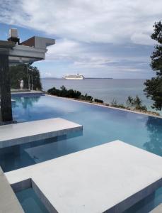 a large swimming pool with a view of the ocean at Viera Resort in Ngurblut +9 photos