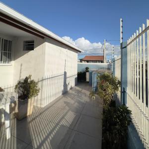 a fence and a sidewalk next to a house at Suíte Quarto 3km de Florianópolis in São José