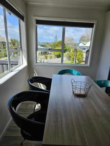 a table and chairs in a room with windows at Podgsters in Mangonui