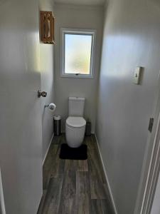 a small bathroom with a toilet and a window at Podgsters in Mangonui