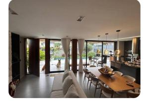 a living room with a white couch and a table at Casa de luxo com piscina in Florianópolis