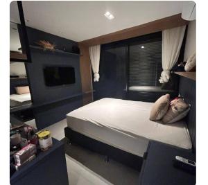 a bedroom with a large bed and a television at Casa de luxo com piscina in Florianópolis