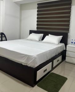 a bed with white sheets and pillows in a room at Oval View Residencies By C in Colombo +4 photos
