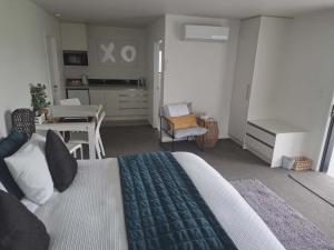 a bedroom with a bed and a table and a kitchen at 54 on Charles at Westshore NAPIER in Napier
