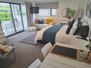 a bedroom with a bed and a living room at 54 on Charles at Westshore NAPIER in Napier