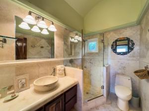 a bathroom with a sink and a shower and a toilet at Belizean Cove Estates Beachfront Villas in San Pedro