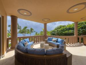 a porch with a couch and chairs on a balcony at Belizean Cove Estates Beachfront Villas in San Pedro