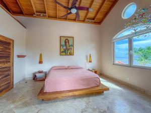 a bedroom with a bed and a ceiling fan at Belizean Cove Estates Beachfront Villas in San Pedro