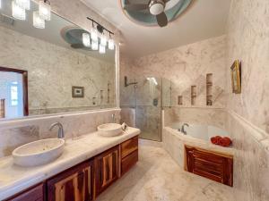 a bathroom with two sinks and a tub and a mirror at Belizean Cove Estates Beachfront Villas in San Pedro +126 photos