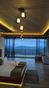 a bedroom with a large bed and a large window at Nilowin Glenanore Guesthouse in Haputale