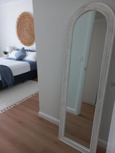 a large white mirror in a bedroom with a bed at Lillian Waters Retreat in Yamba