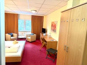 a hotel room with a bed and a desk and a bedroom at Hotel BernsteinSee in Bitterfeld