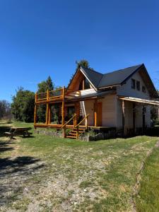a log cabin with a picnic table in front of it at Casa Mallin Azul in El Bolsón