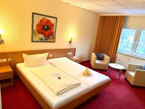 a hotel room with a large bed and a chair at Hotel BernsteinSee in Bitterfeld +29 photos