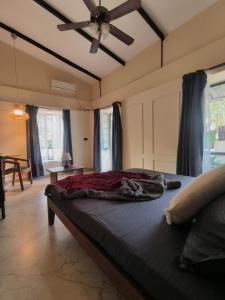 een bed in een kamer met een plafondventilator bij Casa Century in Anjuna