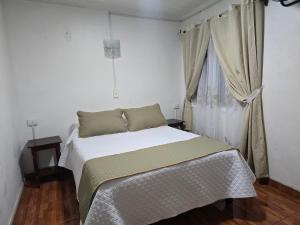 a bedroom with a bed and a window at Andes Hostal Serena in La Serena
