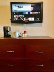 una TV a schermo piatto appesa a un muro con un comò di Casa del Olivo bedroom 3 a Parras de la Fuente