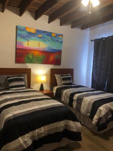 2 letti in una camera con un dipinto sul muro di Casa del Olivo bedroom 3 a Parras de la Fuente