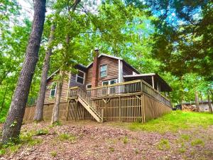 a large house with a large deck in the woods at Cozy Cabin near KentuckyLake in Murray