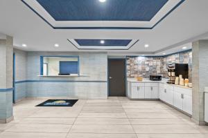 a large kitchen with white cabinets and a blue ceiling at Days Inn by Wyndham Chesapeake in Chesapeake