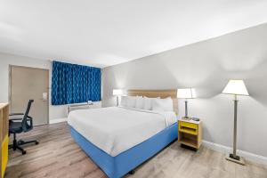a hotel room with a bed and a desk at Days Inn by Wyndham Chesapeake in Chesapeake