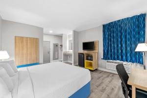 a hotel room with a bed and a table and chairs at Days Inn by Wyndham Chesapeake in Chesapeake