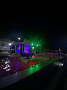 a swimming pool at night with green and purple lights at Viera Resort in Ngurblut