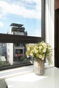 a vase filled with flowers sitting on a window sill at LUMIS TOURANE Hotel in Da Nang